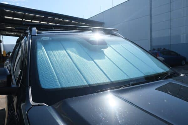 A Ford Ranger 4th generation with a front windscreen shade installed, reflecting sunlight to reduce heat and UV exposure.