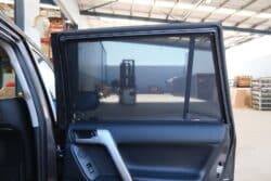 Interior view of a Toyota LandCruiser Prado 150 Series rear door fitted with Snap Shades, providing sun protection and privacy.