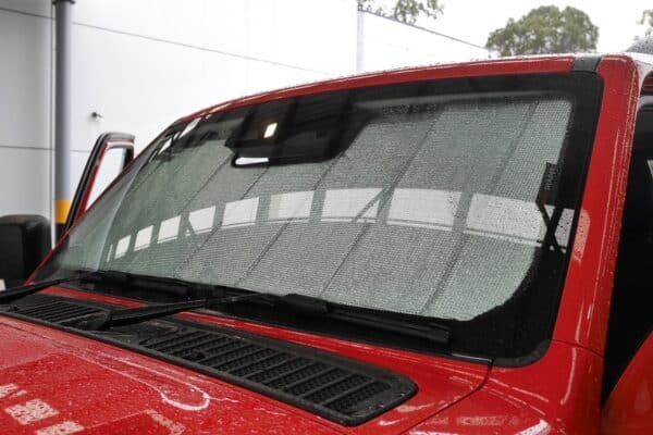 Close-up view of a red Tank 300 with front windscreen sun shades installed, providing effective UV and heat protection.