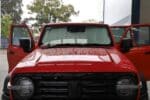 A red Tank 300 with front windscreen sun shades installed, parked in a rainy outdoor setting.