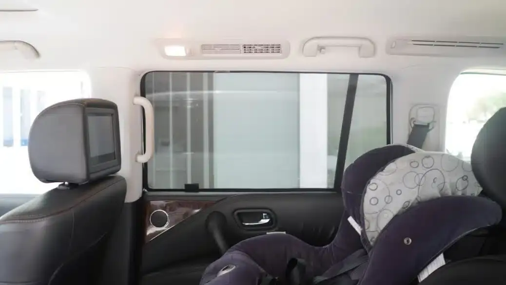 Interior view of a Nissan Patrol showcasing installed Snap Shades on the rear window, alongside a secured baby car seat.