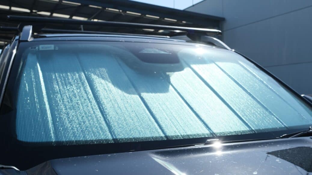 A Ford Ranger 4th generation with a front windscreen shade installed, reflecting sunlight to reduce heat and UV exposure.