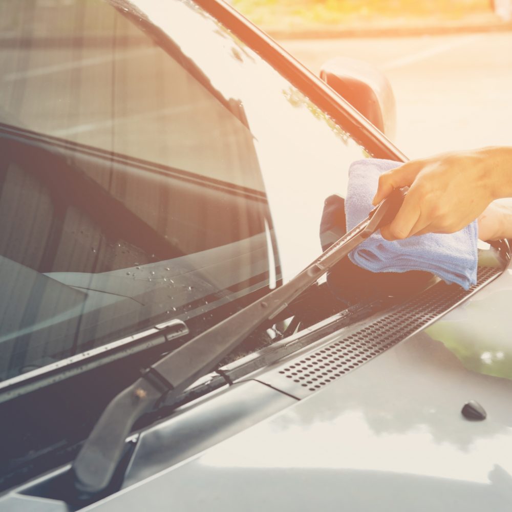 Hand cleaning a car windscreen
