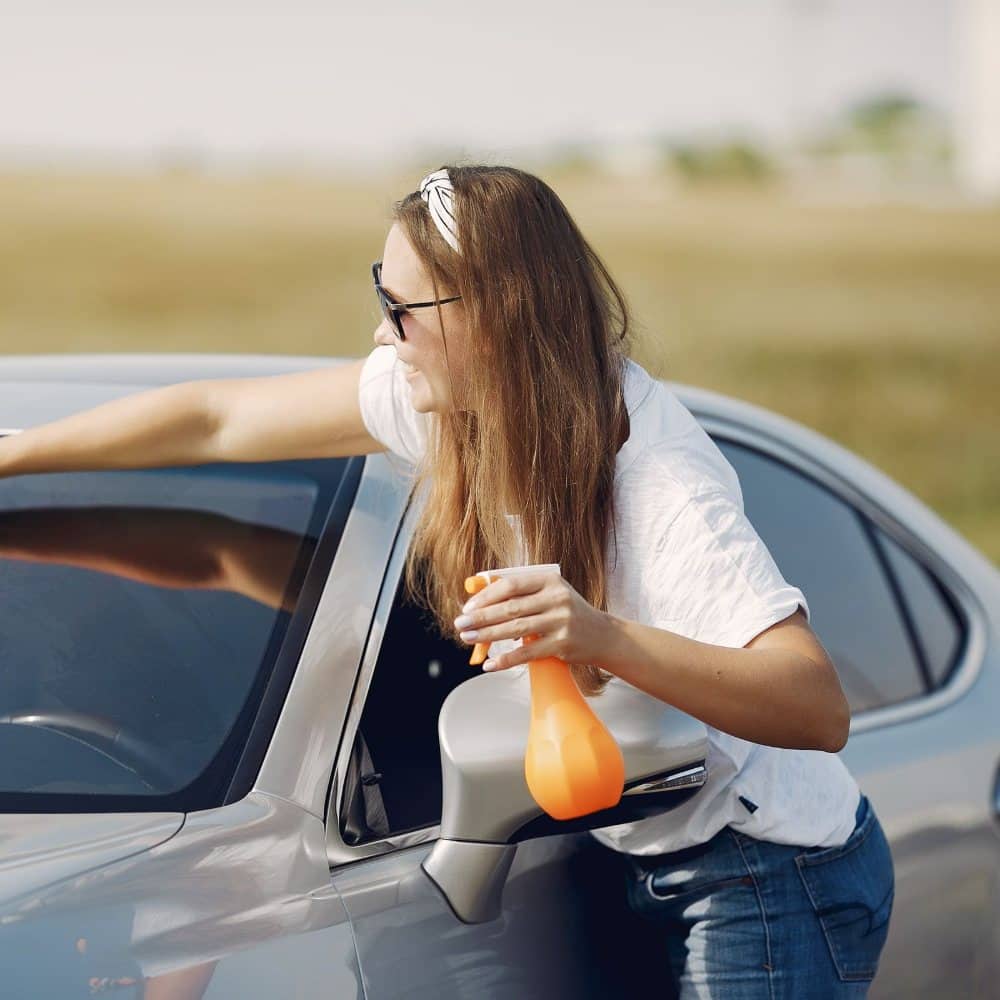 Woman wiping her car windscreen
